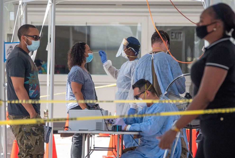 PHOTO: A woman receives a swab test at the COVID-19 walk-up testing service provided by the National Guard, partnered with the City of Miami Beach and the Florida Department of Health, at Miami Beach Convention Center in Miami Beach, Fla., July 15, 2020.