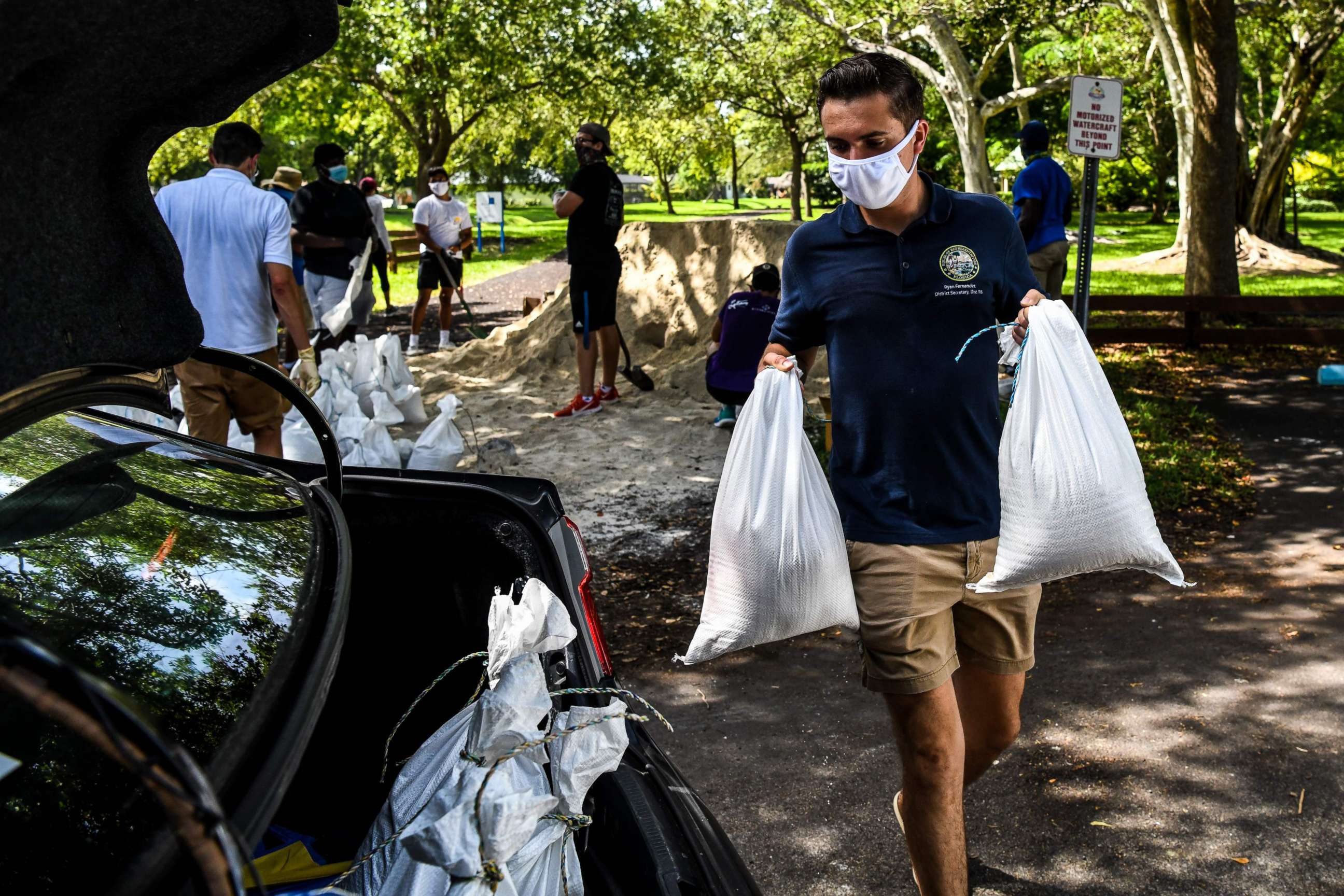 PHOTO: Legislative Assistant Ryan Fernandez, puts sand bags in a resident's car trunk in Palmetto Bay near Miami, on July 31, 2020, as Floridians prepare for Hurricane Isaias while a State of Emergency has been declared for 19 Counties.