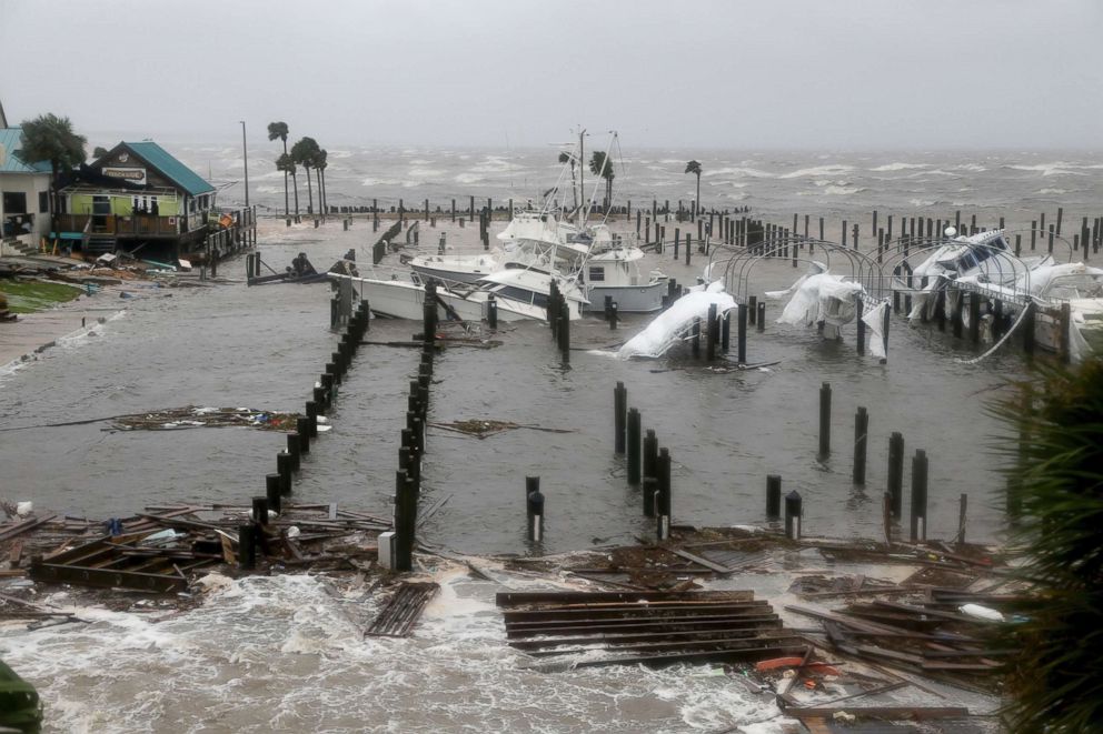 PHOTO: Storm Surge retreats from inland areas, foreground, where boats lay sunk and damaged at the Port St. Joe Marina, Oct. 10, 2018 in Port St. Joe, Fla. 