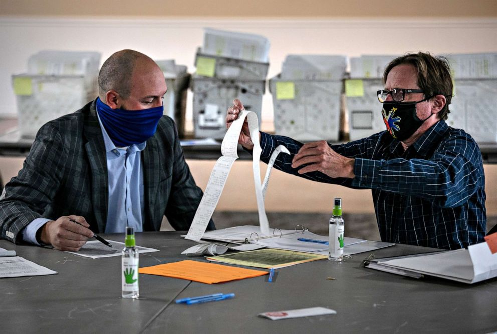 PHOTO: Republican canvasser Anthony Markwort, left, and Democrat Ted Dawson look over ballot tabulator tapes on Nov. 04, 2020, in Mason, Mich.