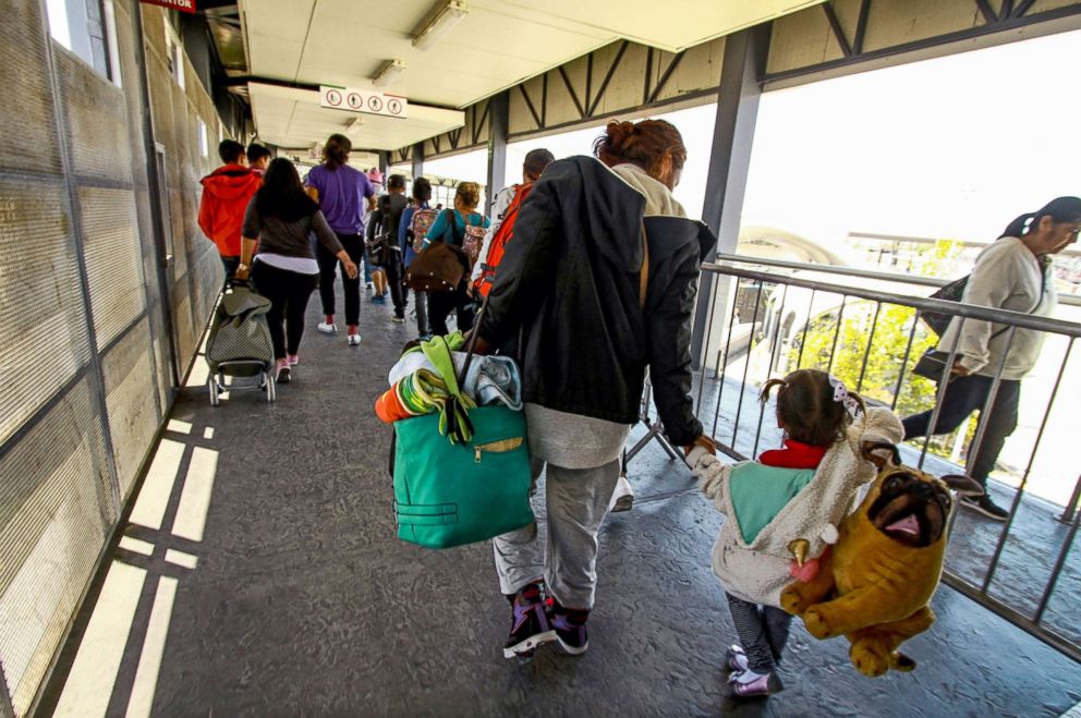 PHOTO: Central American migrants cross into the United States at the El Chaparral border crossing, in Tijuana, Mexico, May 4, 2018.