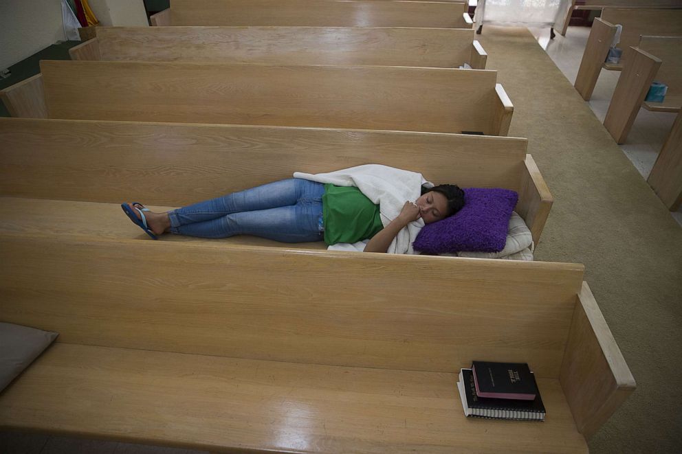 PHOTO: A woman originally from Guatemala sleeps on a pew bench at the El Calvario Methodist Church, after she was released by the U.S. Immigration and Customs Enforcement, June 3, 2019 in Las Cruces, New Mexico.