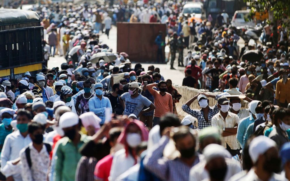 PHOTO: Migrant workers gather for transport to the railway station for their onward journey to their home states, at Dharavi slum in Mumbai, India, on May 26, 2020.