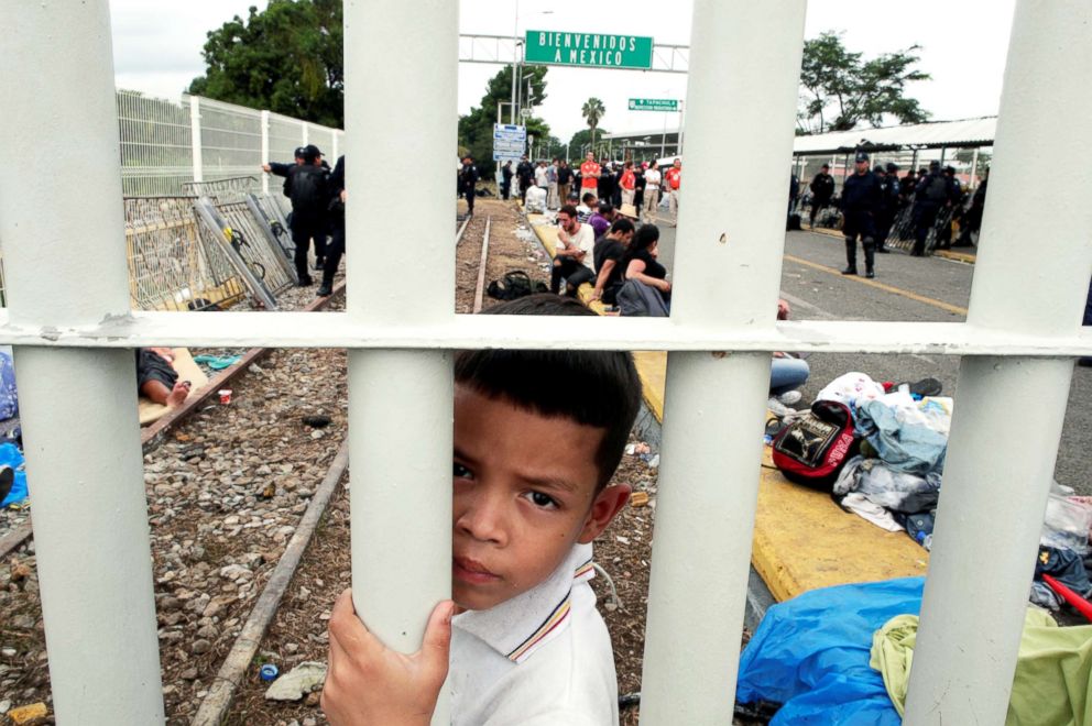 PHOTO: A Honduran migrant child, part of a caravan trying to reach the U.S., looks though the gate on the bridge that connects Mexico and Guatemala in Tecun Uman, Guatemala, Oct. 20, 2018.