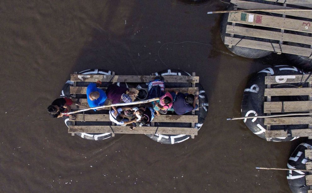 PHOTO: Migrants and residents use a makeshift raft to cross the Suchiate river, natural border between Mexico and Guatemala, in Ciudad Hidalgo, Chiapas state, Mexico, Aug. 10, 2018.