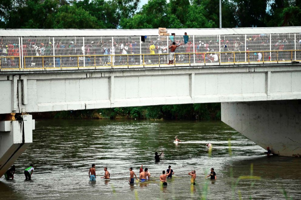 PHOTO: Honduran migrants heading in a caravan to the U.S., wait to help fellow men get down to the Suchiate River from the Guatemala-Mexico international border bridge, in Ciudad Hidalgo, Chiapas state, Mexico, Oct. 20, 2018.