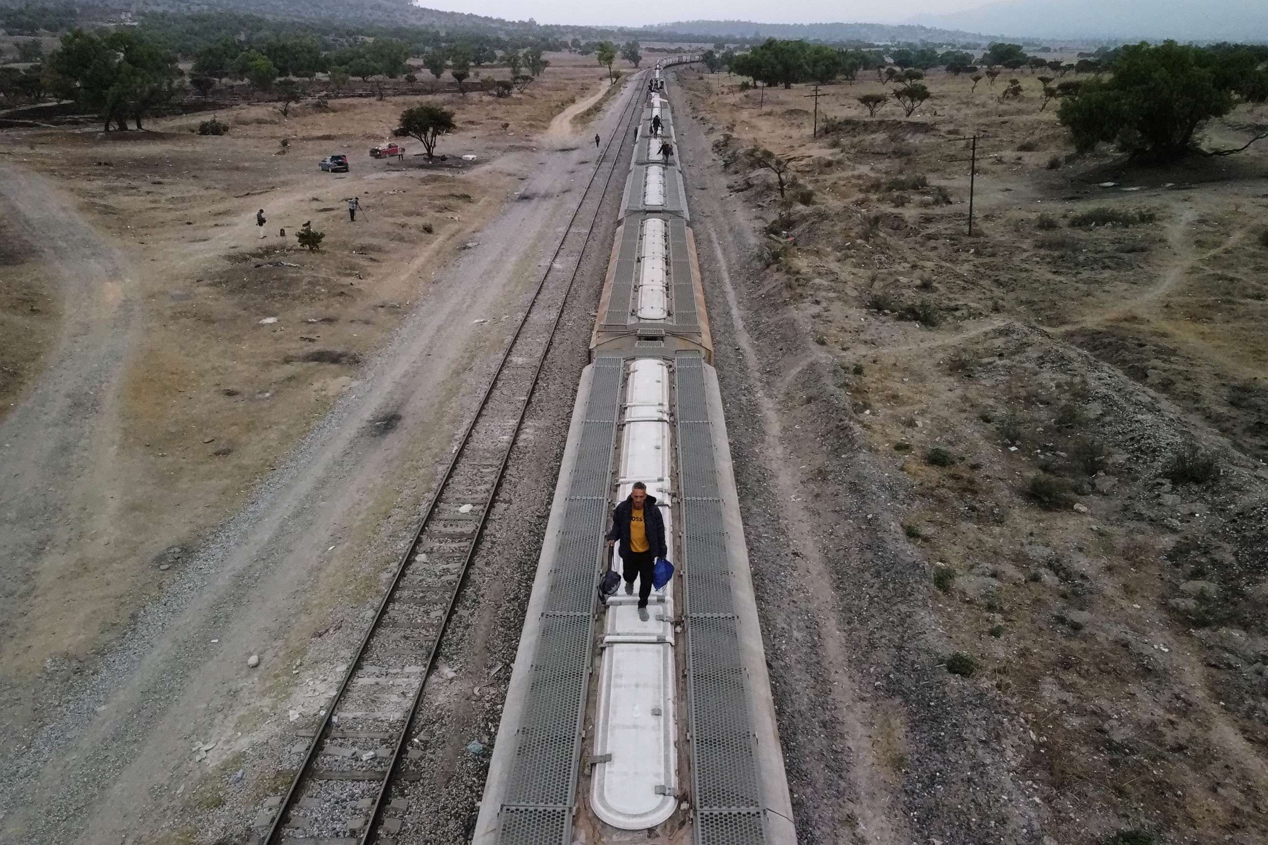 PHOTO: Migrants walk on top of railroad cars as they get ready to continue their journey to the U.S. border in the site known as El Basurero, a stretch of land next to a trash dump and the railroad, in Huehuetoca, State of Mexico, Mexico, April 26, 2023.