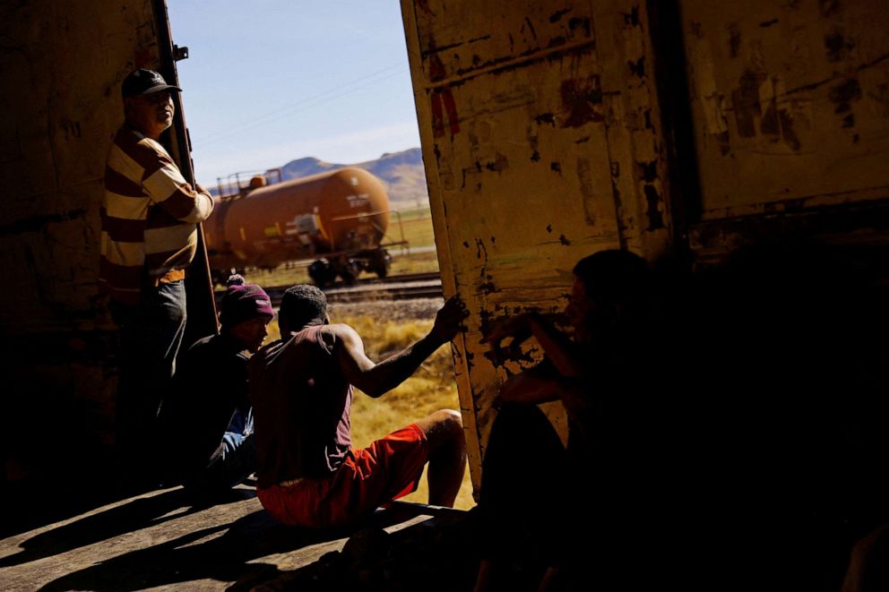 FOTO: Jhon Jairo y Johan Enrique se ven sentados en la puerta de un vagón mientras viajan en tren con la intención de llegar a los Estados Unidos, en las afueras de Ciudad Juárez, México, el 19 de abril de 2023.