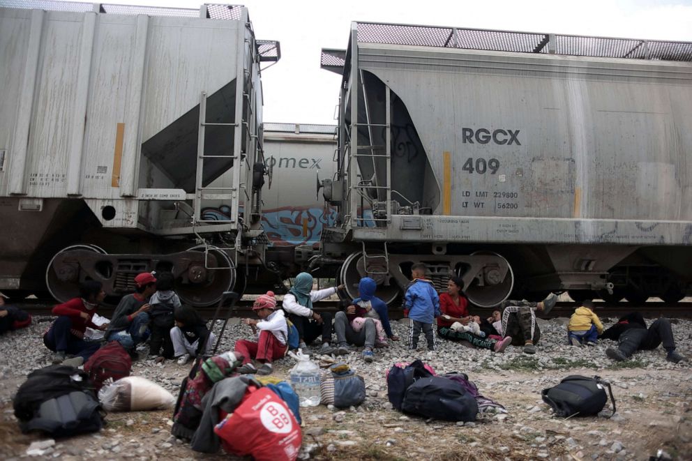 Los migrantes descansan sobre las vías en lo que se conoce como El Basurero, un tramo de tierra junto a un basurero y la vía férrea, mientras esperan un tren para continuar su viaje hacia la frontera de Estados Unidos en Huehuetoca, Estado de México, México, abril 14, 2023.