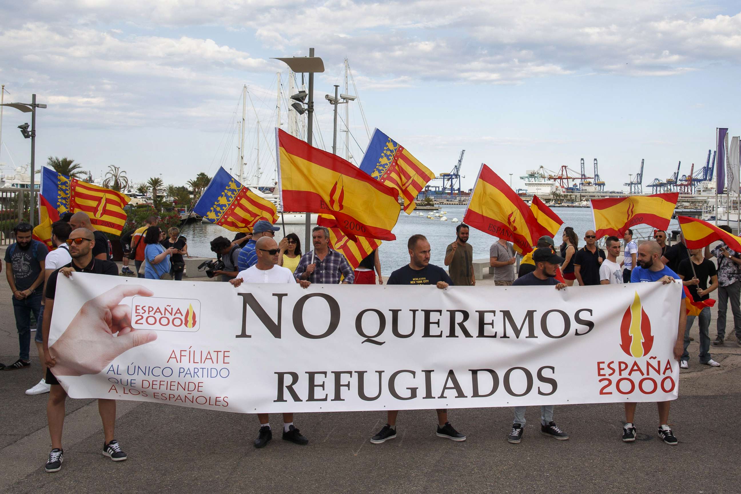 PHOTO: Protesters hold Spanish flags and a banner reading 'We don't want refugees' as they demonstrate against the arrival of migrants aboard the Aquarius ship at the port of Valencia, June 16, 2018 in Valencia, Spain.