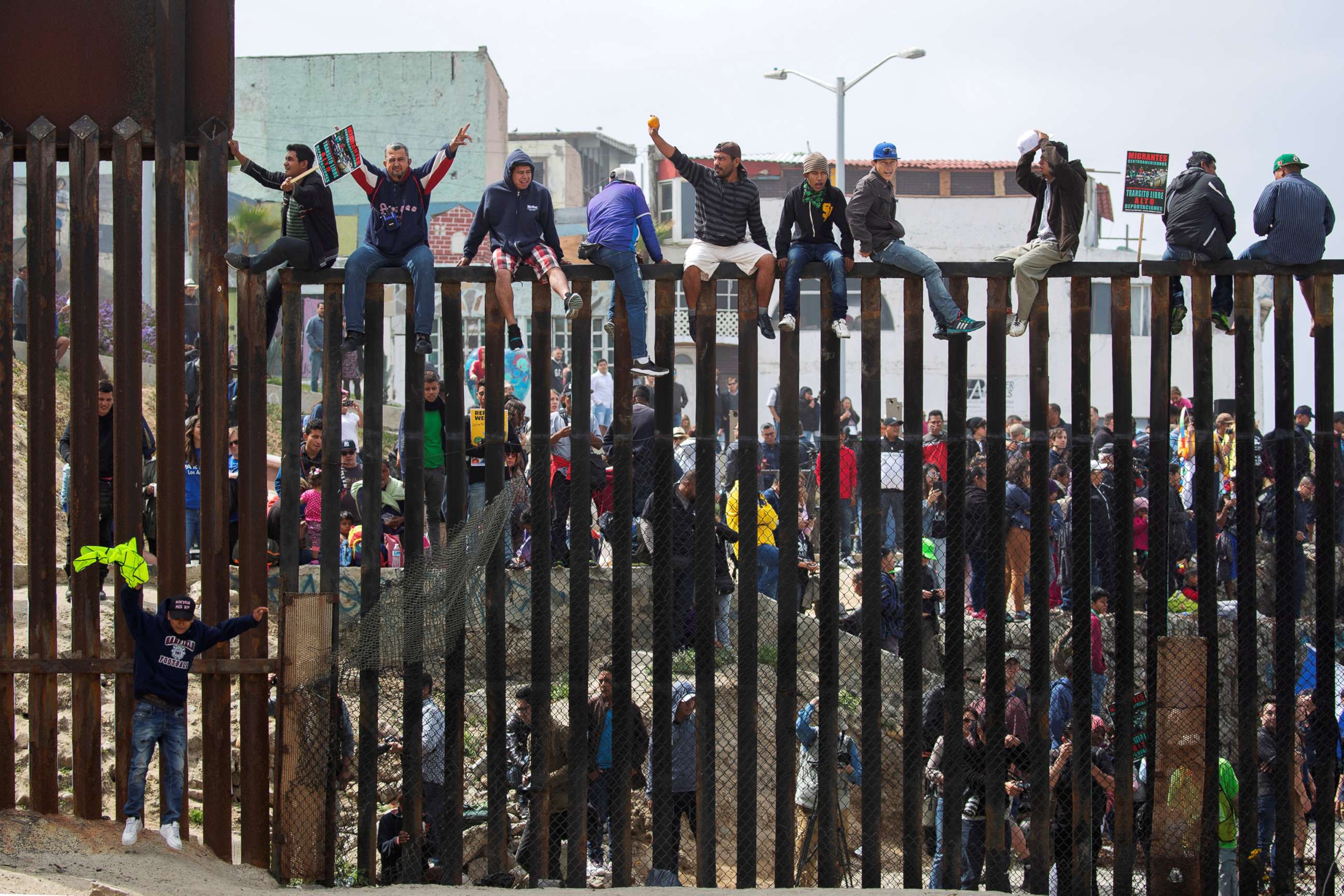 PHOTO: People in Mexico climb the border wall fence as a caravan of migrants and supporters reached the United States-Mexico border near San Diego, Calif., April 29, 2018. 
