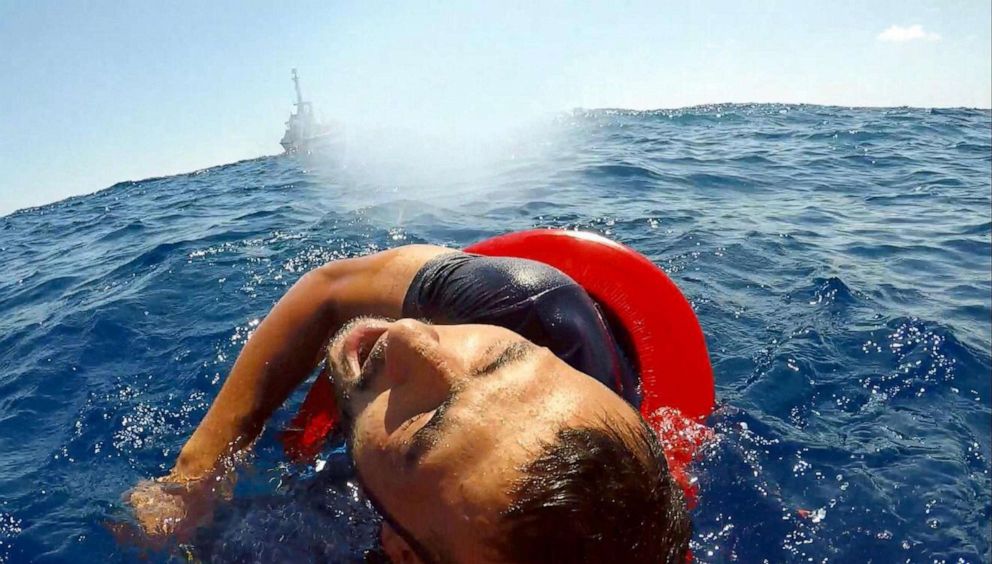 PHOTO: A migrant is rescued at sea after diving from the Open Arms ship off the coast of Lampedusa, southern Italy, Aug. 20, 2019.