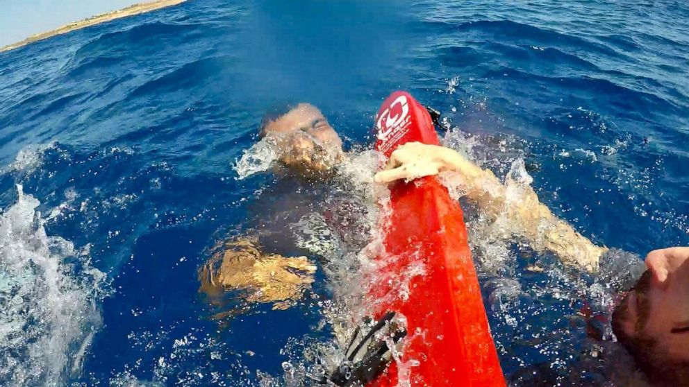 PHOTO: A migrants is rescued at sea after diving from the Open Arms ship, off the coast of Lampedusa, Italy,  Aug. 20, 2019.