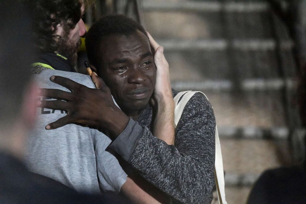 PHOTO:A man cries as he hugs a crew member after disembarking from the Open Arms rescue ship on the Sicilian island of Lampedusa, southern Italy, Aug. 20, 2019.