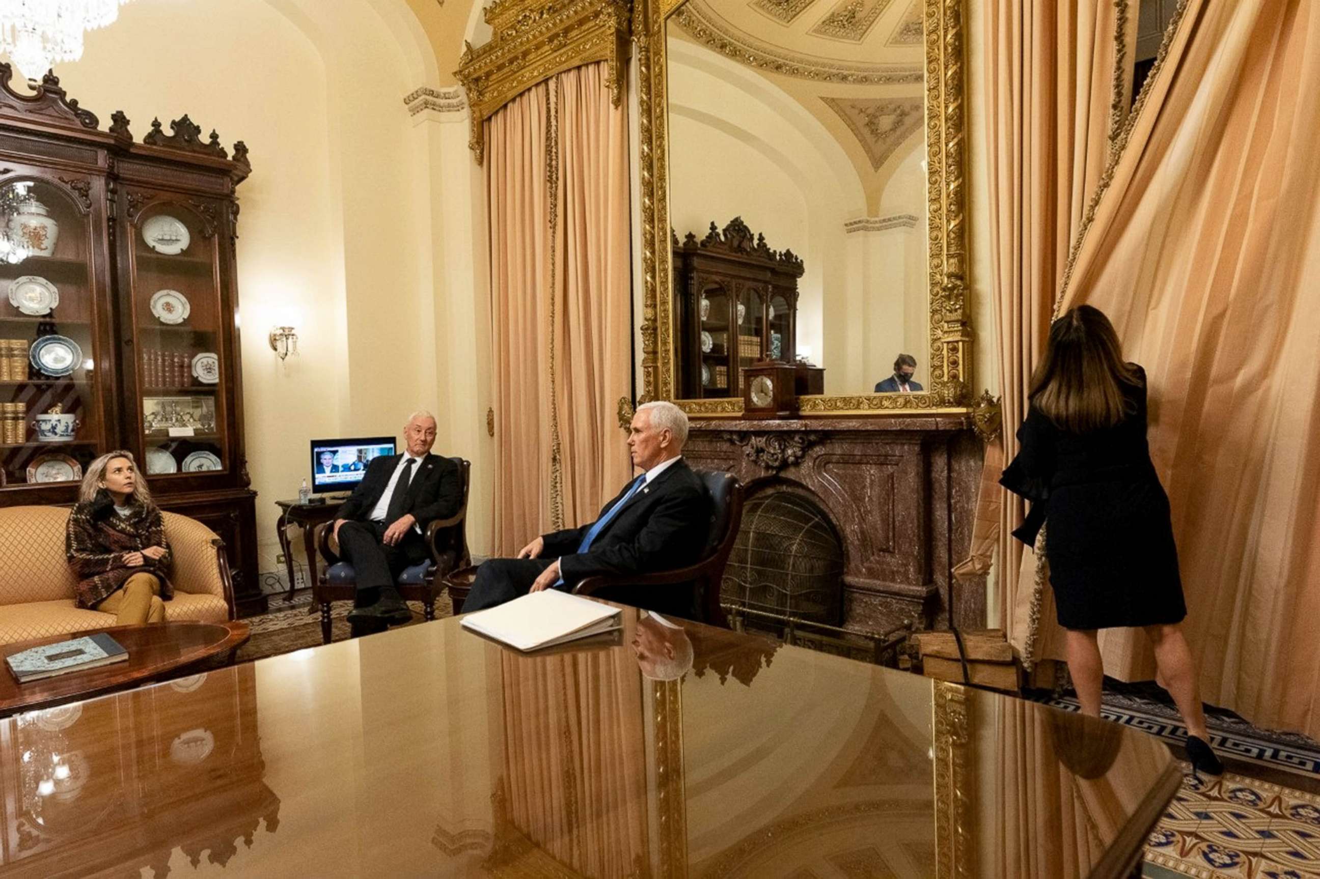 PHOTO:  Vice President Mike Pence sits with his daughter and brother while wife Karen draws the curtains in ceremonial room off Senate floor where he was evacuated to as Trump supporters attacked U.S. Capitol, Jan. 6, 2021,