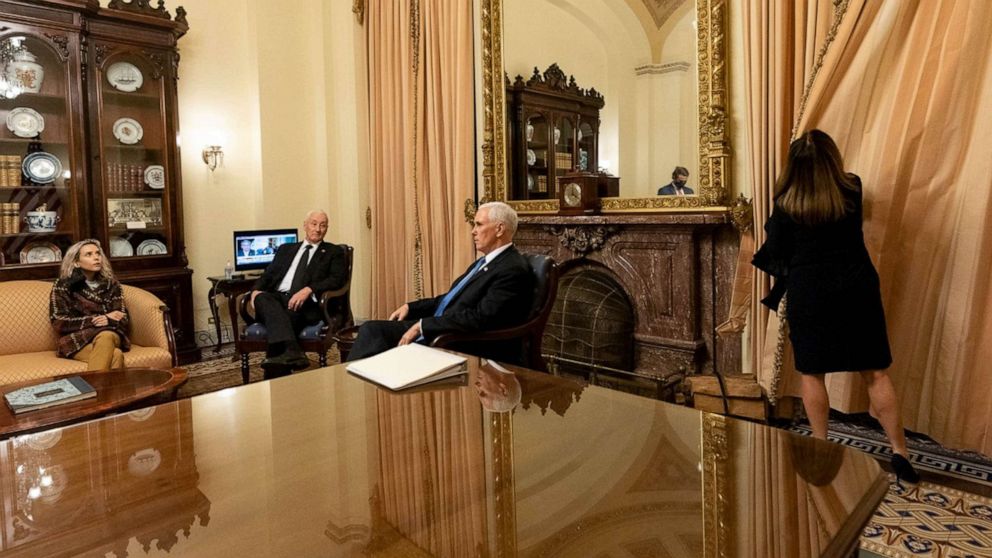 PHOTO:  Vice President Mike Pence sits with his daughter and brother while wife Karen draws the curtains in ceremonial room off Senate floor where he was evacuated to as Trump supporters attacked U.S. Capitol, Jan. 6, 2021,