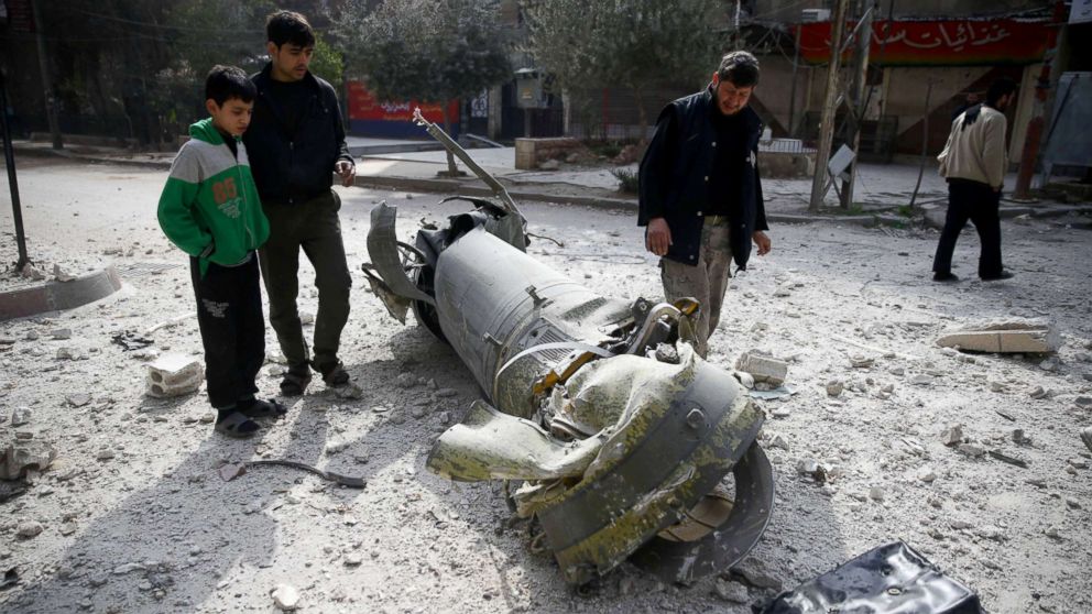PHOTO: People inspect missile remains in the besieged town of Douma, in eastern Ghouta, Syria, Feb. 23, 2018.