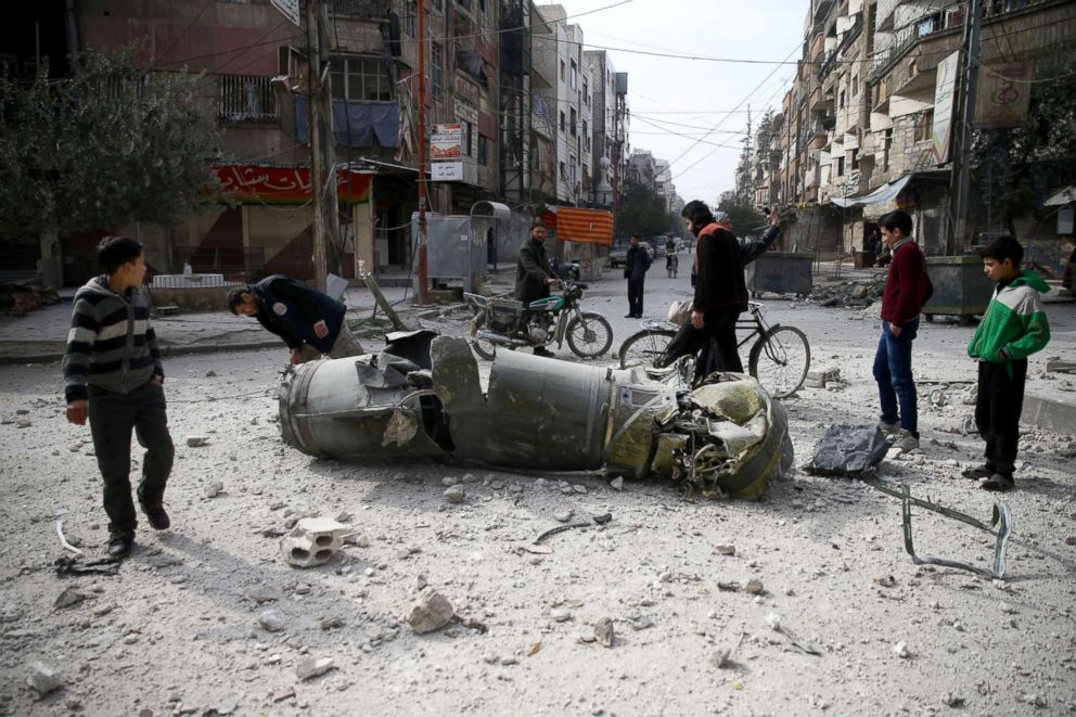 PHOTO: People inspect missile remains in the besieged town of Douma, in eastern Ghouta, Syria, Feb. 23, 2018.
