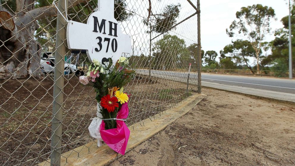 Flowers and a memorial for the missing passengers of flight MH370 are attached to the perimeter fence of RAAF Pearce Airbase on March 26, 2014 in Bullsbrook, 35km north of Perth, Australia.