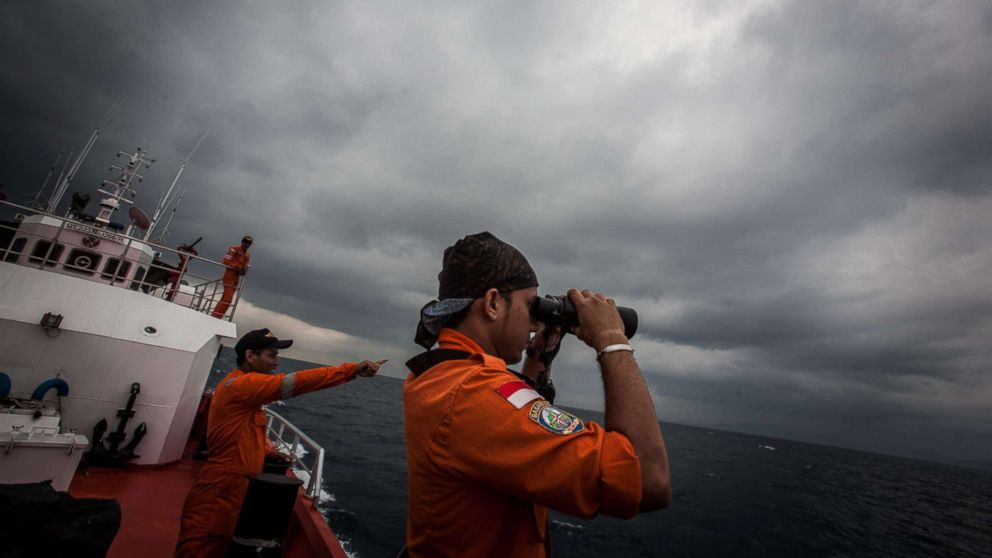 Indonesian national search and rescue agency personel watch over high seas during a search operation for missing Malaysia Airlines flight MH370 in the Andaman Sea on March 15, 2014.