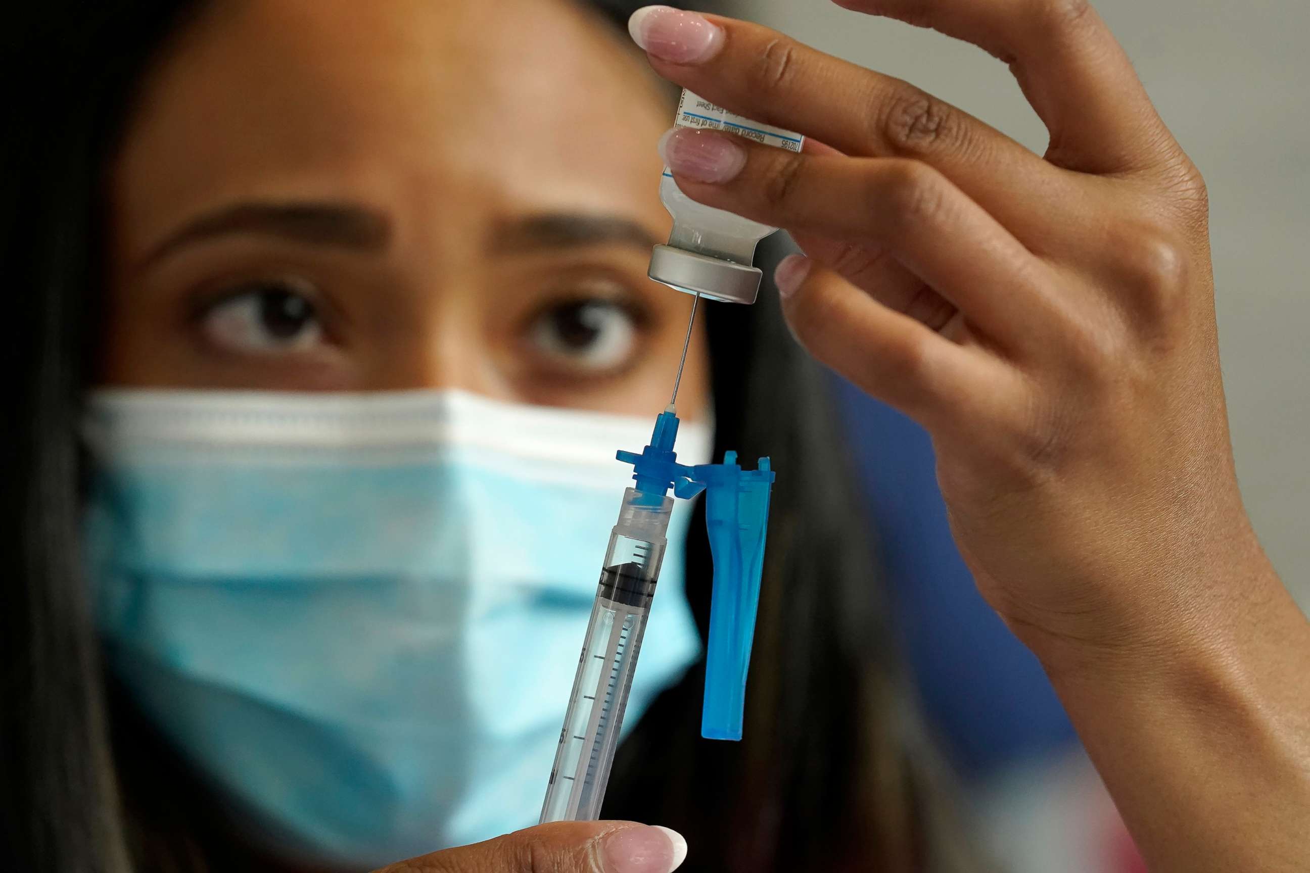 PHOTO: Licensed practical nurse Yokasta Castro, of Warwick, R.I., draws a Moderna COVID-19 vaccine into a syringe at a mass vaccination clinic, May 19, 2021, at Gillette Stadium, in Foxborough, Mass.