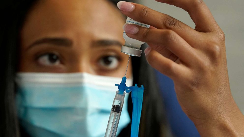 PHOTO: Licensed practical nurse Yokasta Castro, of Warwick, R.I., draws a Moderna COVID-19 vaccine into a syringe at a mass vaccination clinic, May 19, 2021, at Gillette Stadium, in Foxborough, Mass.