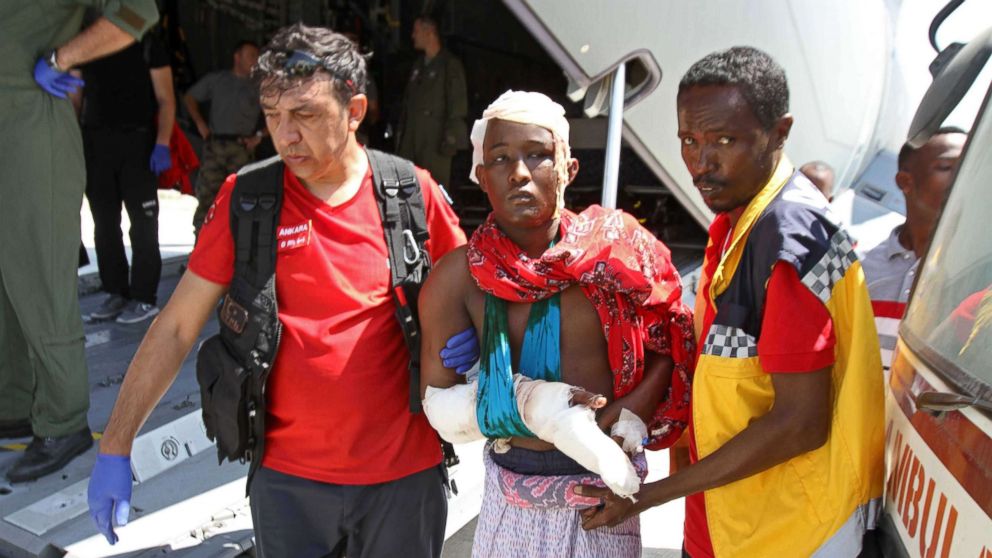 Turkish and Somali paramedics help a wounded man to a Turkish military plane transporting the injured to Turkey at the Mogadishu airport, Oct. 16, 2017, after a truck bomb explosion in the Somali capital. The attack left more than 200 people dead.