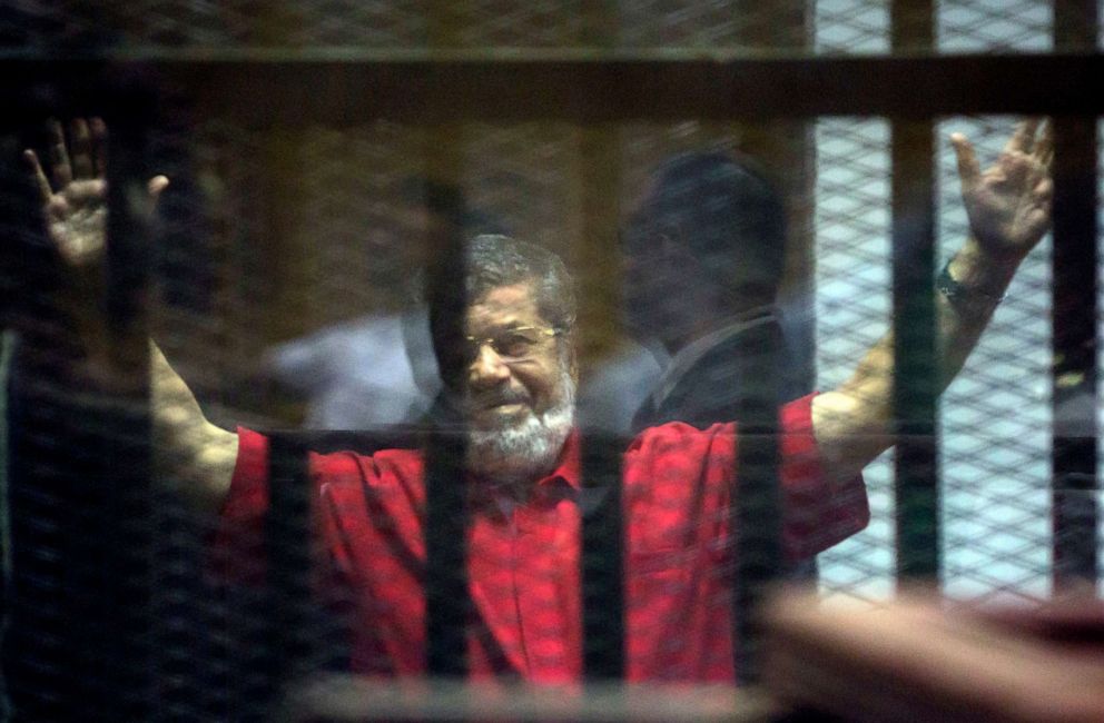 PHOTO: Former Egyptian President Mohammed Morsi raises his hands inside a defendants cage in a makeshift courtroom at the national police academy, in an eastern suburb of Cairo, Egypt, June 18, 2016.