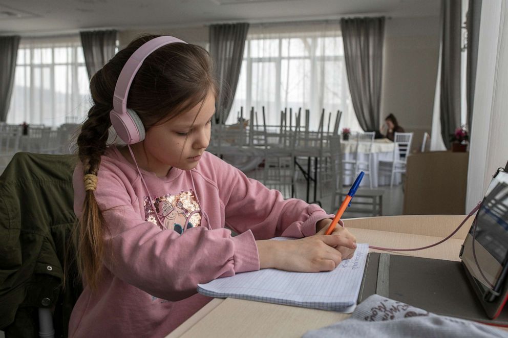 PHOTO: 8-year-old Amalia, a refugee from Ukraine, studies at a small desk inside the food hall at Costesti resort hotel in Chisinau, Moldova, March 29, 2022.