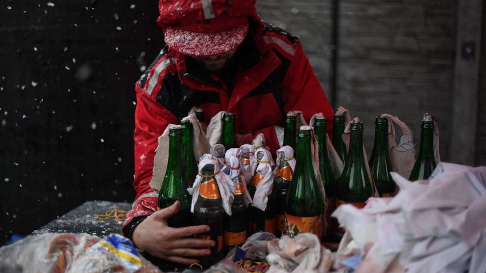 PHOTO: A volunteer demonstrates the preparation of Molotov cocktails in Lviv on Feb. 27, 2002.