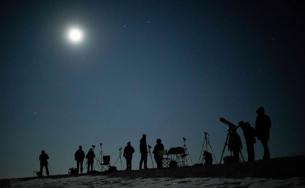 PHOTO: People gather as they wait for the appearance of a 'blood moon' total lunar eclipse over Vienna, Jan. 21, 2019.