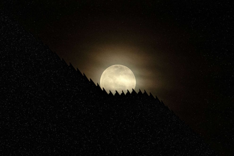 PHOTO: The US-Mexico border fence is silhouetted by the moon light in Tijuana, in Baja California state, Mexico, Jan. 20, 2019.