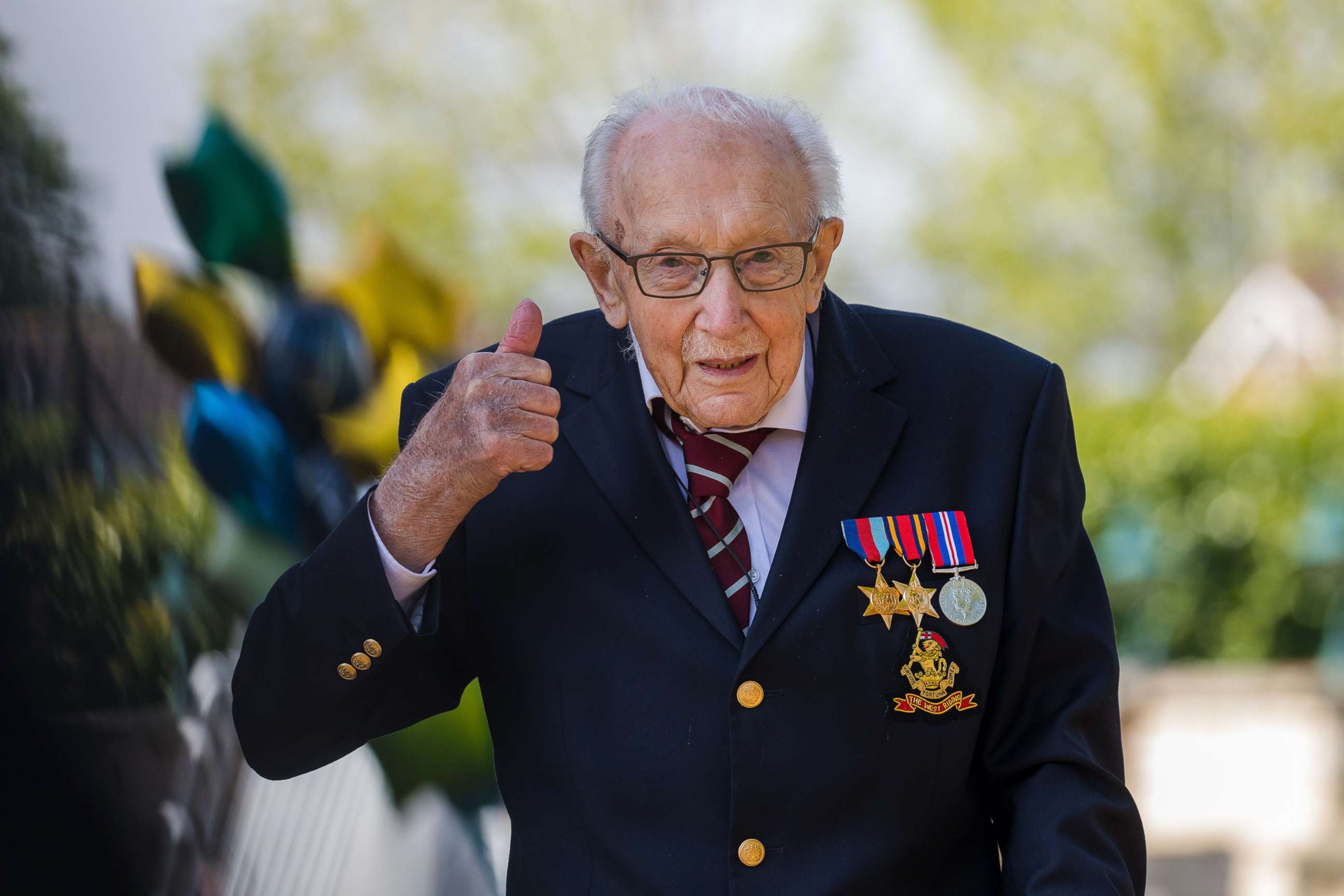 PHOTO: British veteran Captain Tom Moore reacts after completing the 100th length of his back garden in Marston Moretaine, Bedfordshire, Britain, April 16, 2020. 