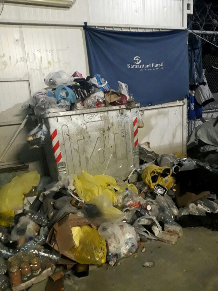  Trash spills out of overflowing garbage bins in the Moria refugee camp on the Greek island of Lesbos.