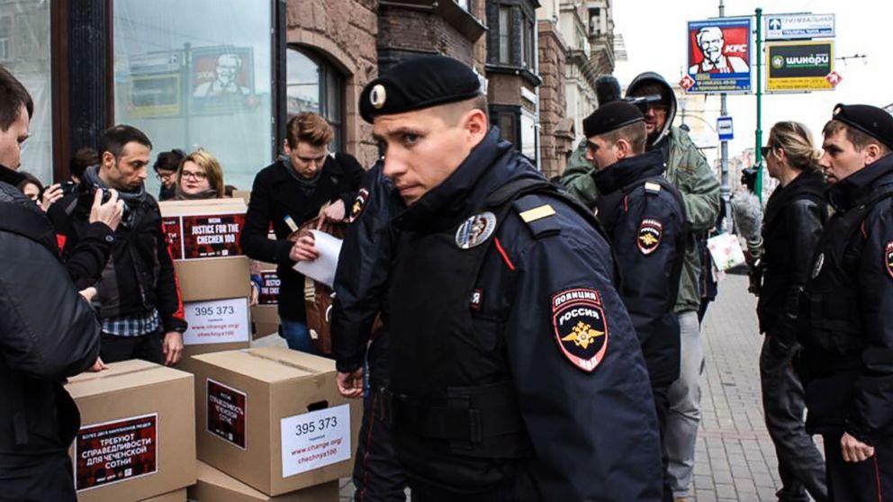 Russian policemen surround Russian gay-rights activists standing next to boxes allegedly containing signed petitions calling for a probe into a reported crackdown on Chechnya's LGBT community, during a rally in central Moscow on May 11, 2017.