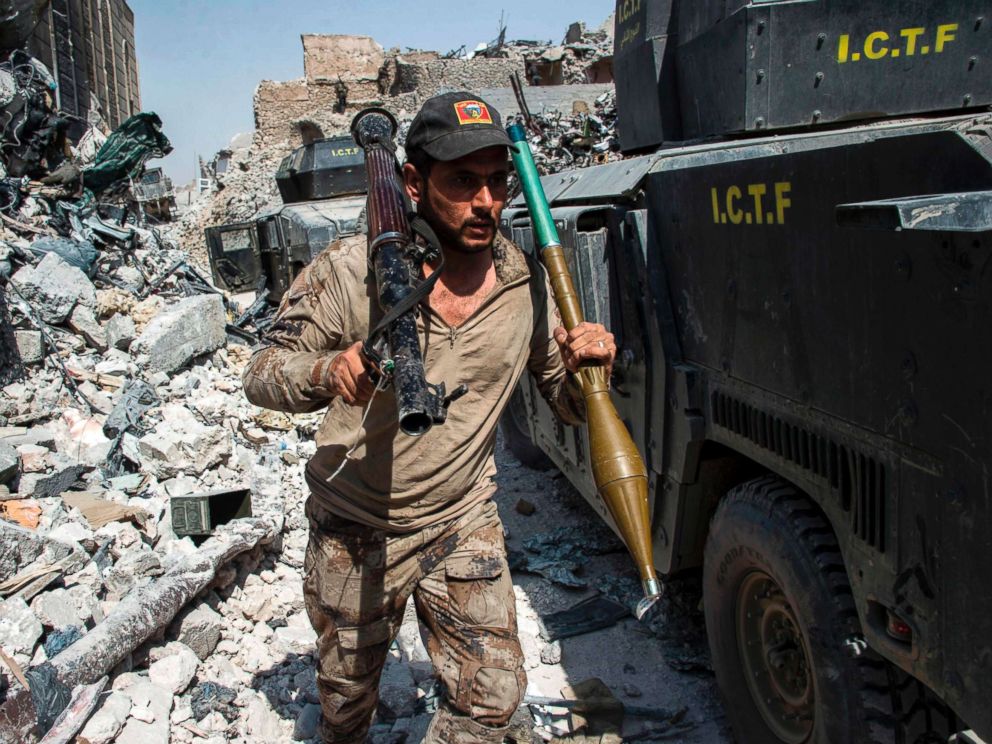 PHOTO: A member of the Iraqi forces walks through the rubble past humvees as he carries a rocket-propelled grenade and launcher in the Old City of Mosul, July 10, 2017.