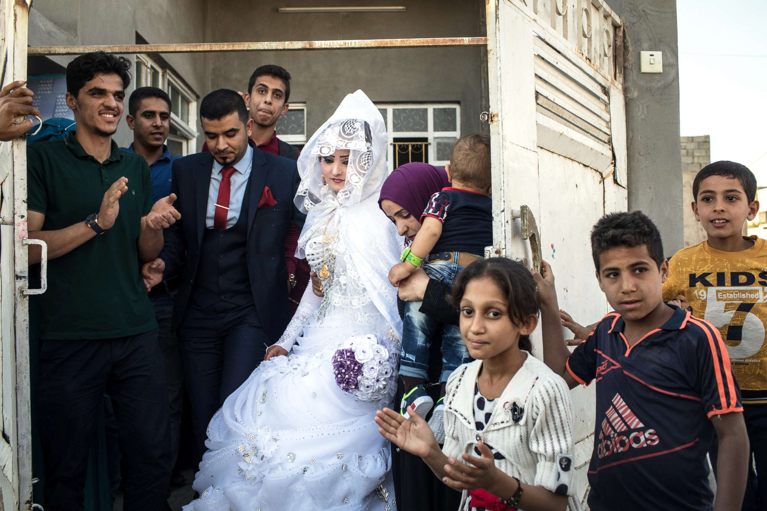 PHOTO: Family members watch on as a bride and groom leave their house to be married in West Mosul on Nov. 3, 2017.