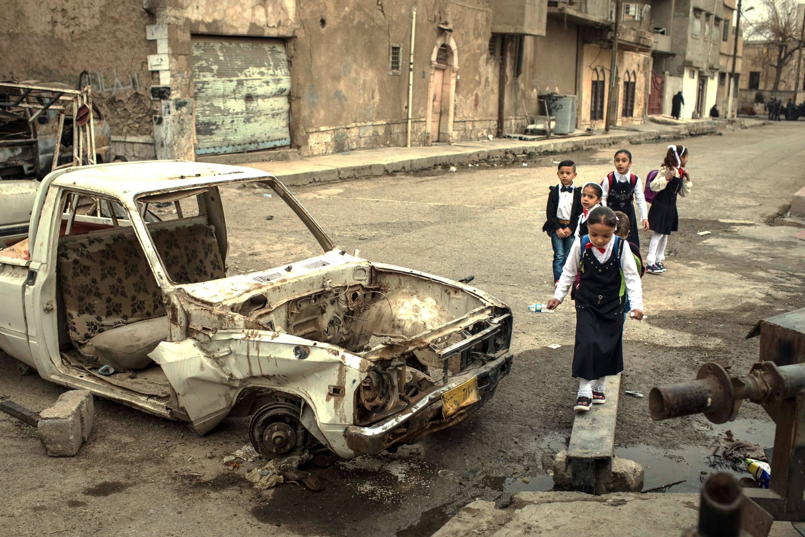 PHOTO: Children walk to school past destroyed cars in West Mosul on Nov. 6, 2017.