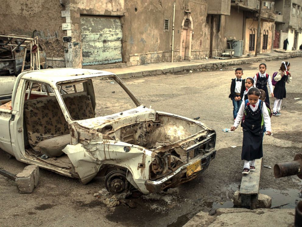 PHOTO: Children walk to school past destroyed cars in West Mosul on Nov. 6, 2017.