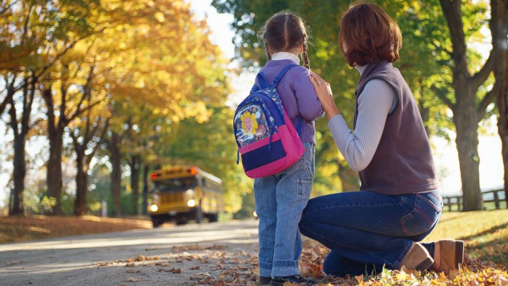 A mother and her daughter wait for the school bus in this undated photo.
