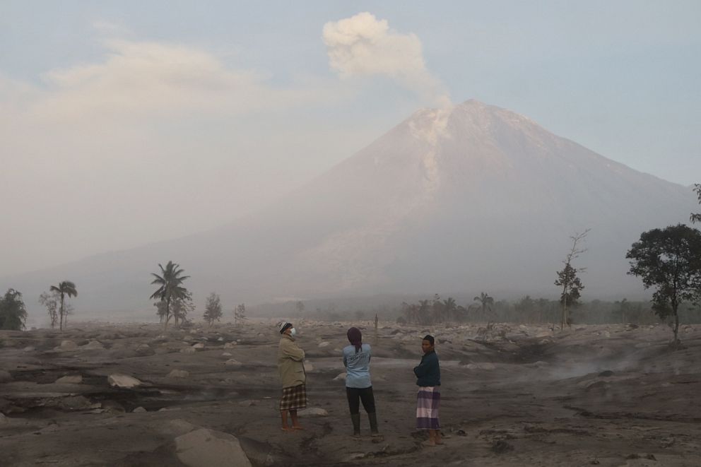 PHOTO: People are seen as Mount Semeru continues to spew volcanic ash after its eruption, Dec. 5, 2022, in Lumajang Regency, Indonesia. 