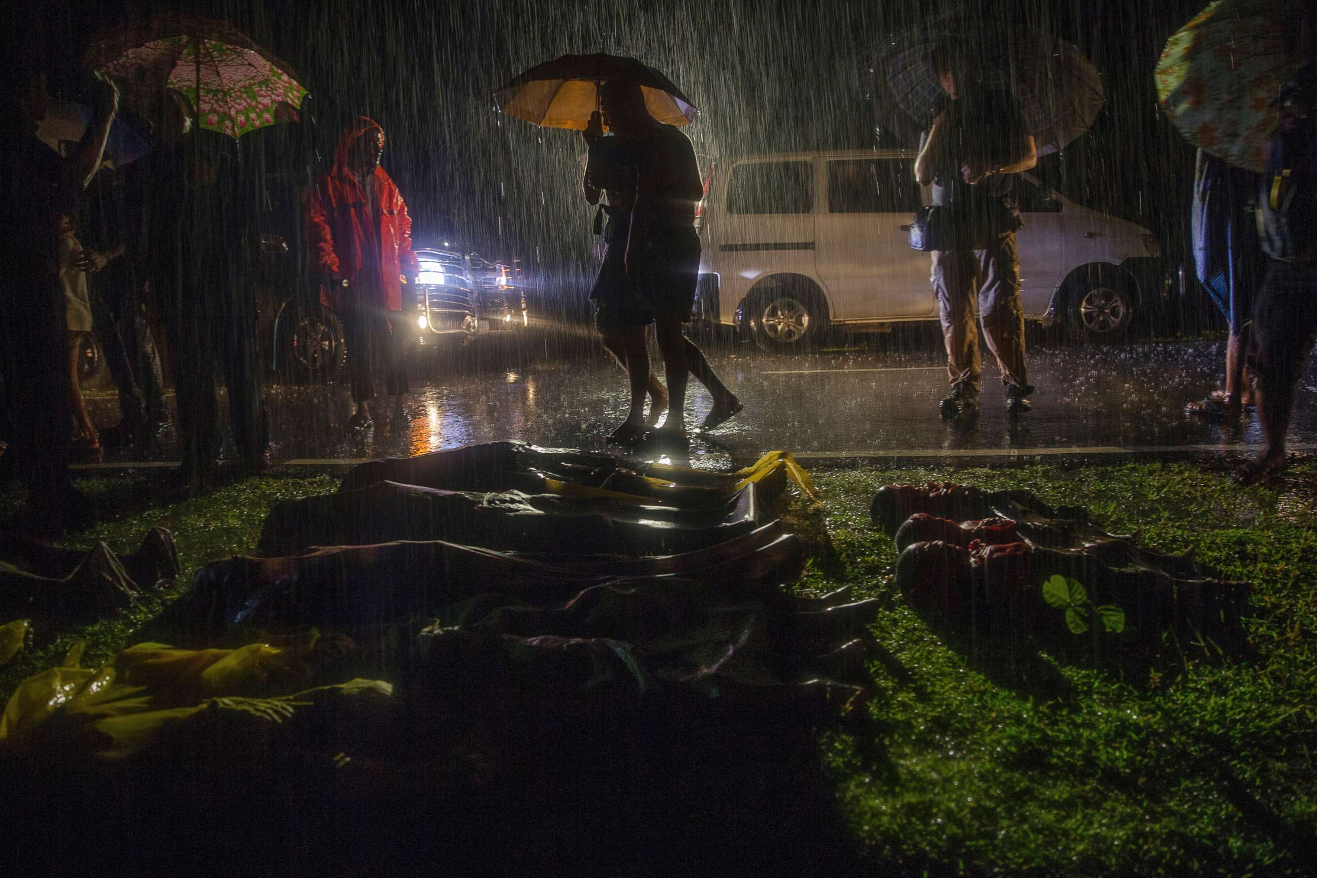 PHOTO: People walk past bodies of Rohingya Muslims, who died after their boat capsized in the Bay of Bengal as they were crossing over from Myanmar into Bangladesh, Sept. 28, 2017. 