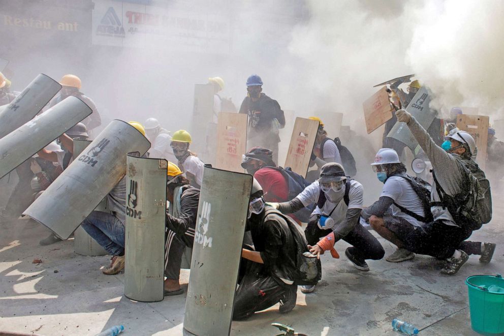 PHOTO: Protesters take cover as they clash with riot police officers during a protest against the military coup in Yangon, Myanmar, Feb. 28, 2021. 