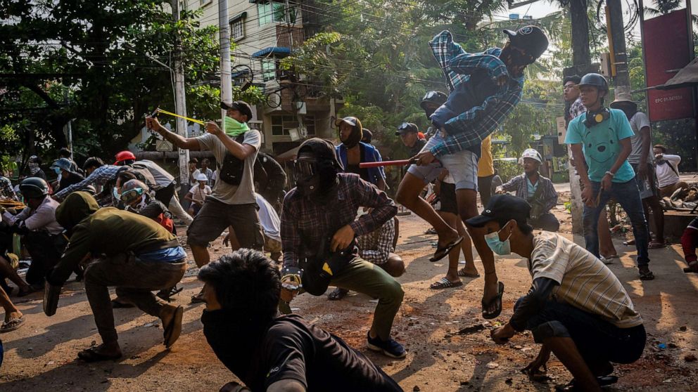PHOTO: Protesters use slingshots and pelt stones towards approaching security forces on March 28, 2021 in Yangon, Myanmar.