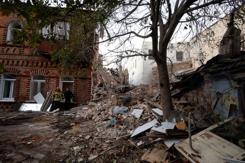 PHOTO: Rescuers stand next to a building heavily damaged by a Russian missile strike, amid Russia's attack on Ukraine, in Mykolaiv, Ukraine, in Oct. 18, 2022.