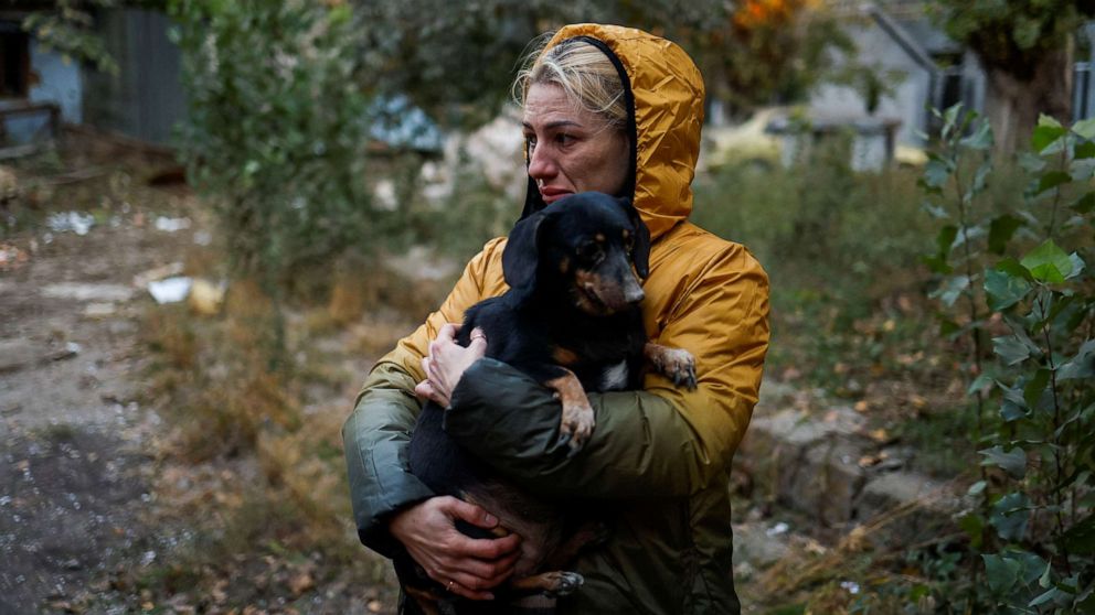PHOTO: A woman carries a dog at a site of a residential building heavily damaged by a Russian missile strike, amid Russia's attack on Ukraine, in Mykolaiv, Ukraine, on Oct. 18, 2022.