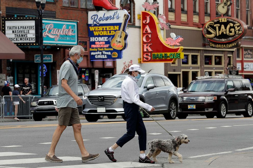 PHOTO: People wear masks as they cross Broadway, June 30, 2020, in Nashville, Tenn.