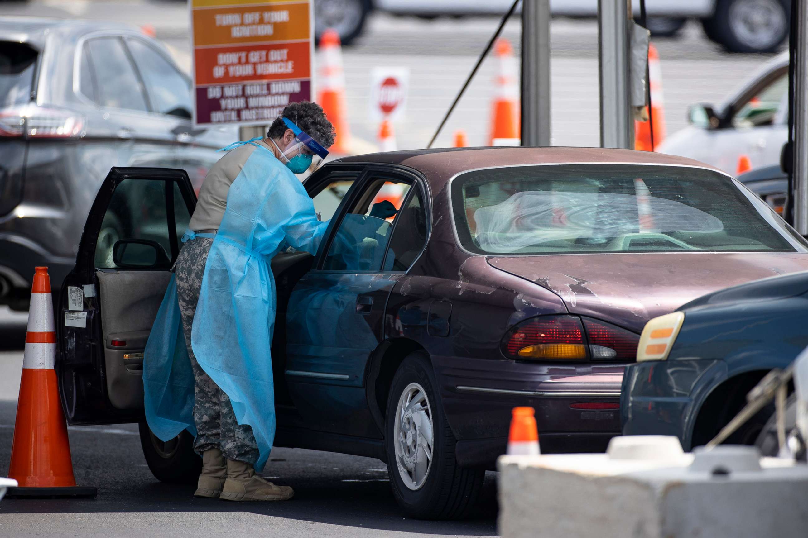 PHOTO: Healthcare workers test people in their car at a COVID-19 testing center outside Nissan Stadium on Aug. 3, 2020, in Nashville.