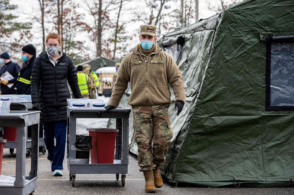 PHOTO: A soldier pulls a cart full of medical equipment and syringes loaded with the Moderna COVID-19 vaccines to be given to people in their cars at a vaccination center in Londonderry, New Hampshire on Feb. 4, 2021.