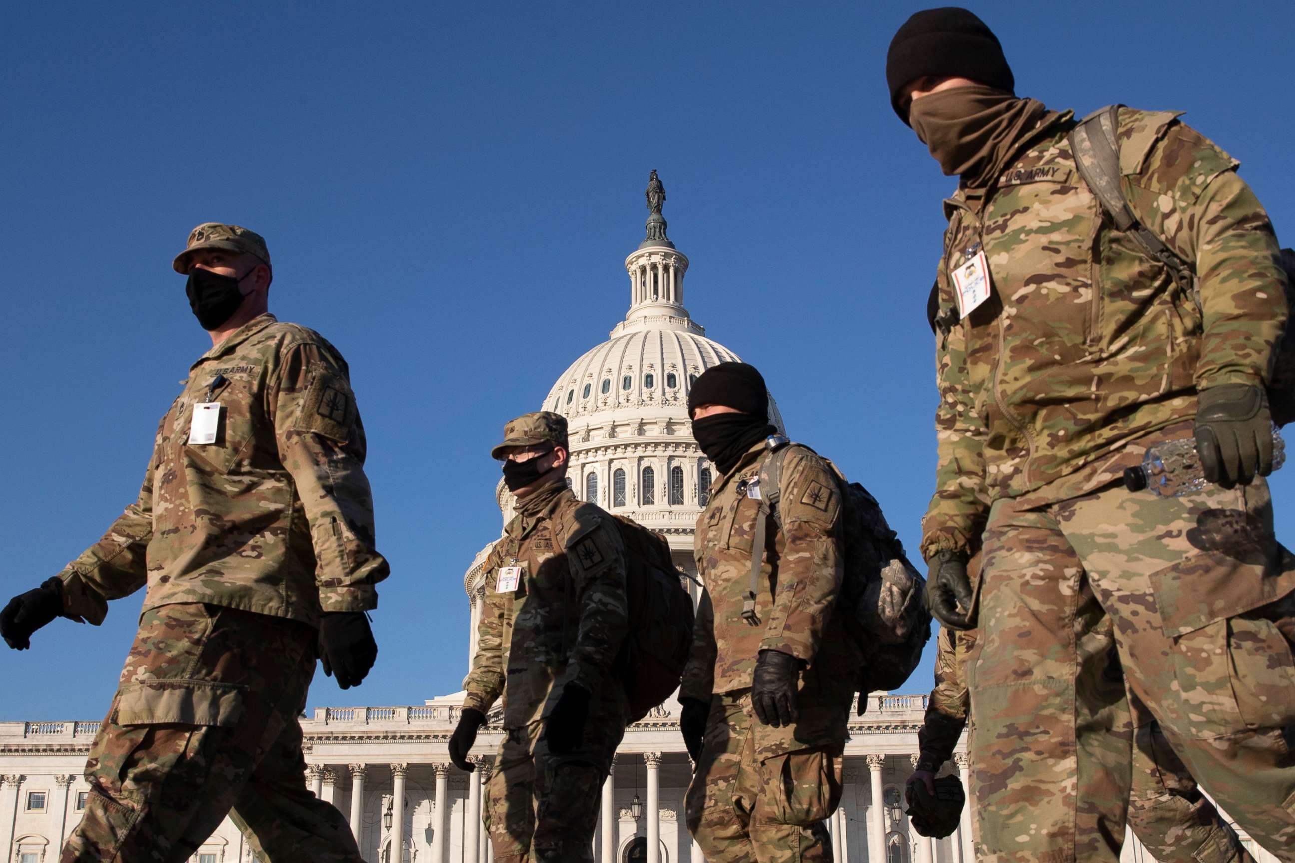 PHOTO: Members of the National Guard walk on the grounds of the East Front of the U.S. Capitol in Washington, D.C, Jan. 12, 2021.